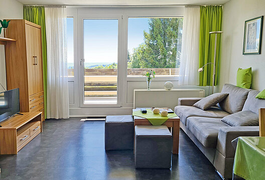 Das Bild zeigt den Wohnraum der Ferienwohnung Sorgenfrei im Ortsteil Predigtstuhl. Von der Wohnung und dem Balkon hat man einen herrlichen Blick in die Landschaft.